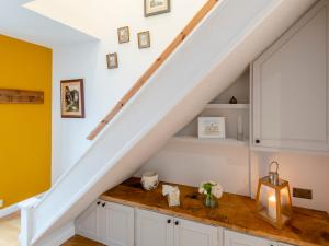 a kitchen under the stairs with a wooden counter top at Strugglers Retreat - Uk32878 in Lincoln
