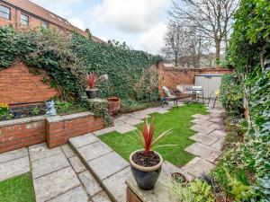 a small garden with a patio with a table and plants at Strugglers Retreat - Uk32878 in Lincoln