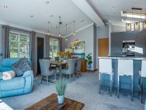 a living room with a blue couch and a table at 36 At The Sanctuary - Uk50278 in Carnguwch +45 photos