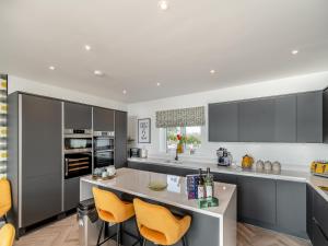 a kitchen with gray cabinets and yellow chairs at Sandbanks in Bridlington