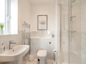 a bathroom with a toilet and a sink and a shower at Sandbanks in Bridlington +25 photos