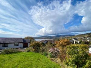 a house on a hill with a green yard at Seagrass in Lamlash