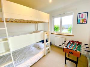 a bedroom with two bunk beds and a desk at Seagrass in Lamlash