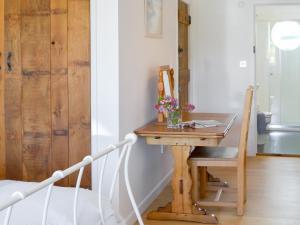 a room with a wooden desk with a vase of flowers at Roskear in Crackington Haven