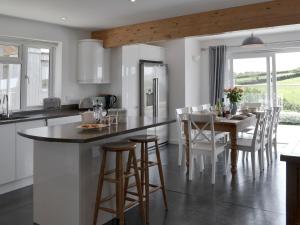 a kitchen with a large island with a table and chairs at Roskear in Crackington Haven