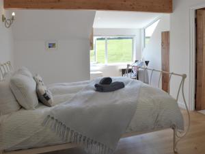 a bed with a blanket on it in a bedroom at Roskear in Crackington Haven