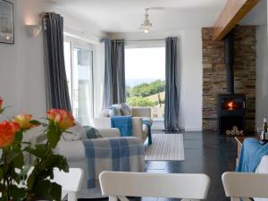 a living room with a couch and chairs and a fireplace at Roskear in Crackington Haven +15 photos