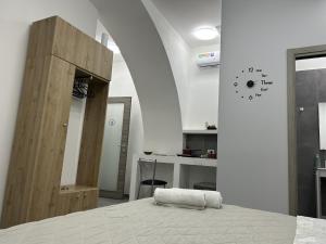 a bedroom with a bed and a wooden cabinet at La Pescheria - Mini Apartments in Catania