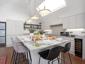 a kitchen with a large white table with chairs at Bimblebox Stable in Reepham