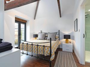 a bedroom with a bed in a room with white walls at Bimblebox Stable in Reepham