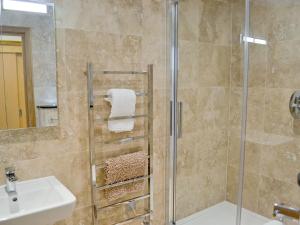 a bathroom with a shower and a sink at Gylly Beach View - Tor in Falmouth