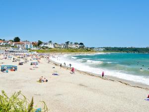 a group of people on a beach near the ocean at Gylly Beach View - Tor in Falmouth
