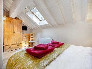a bedroom with a large bed with red pillows on it at The Rose- Uk47155 in Burgh le Marsh