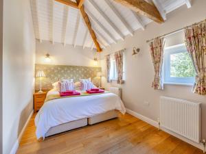 a bedroom with a large white bed with pink pillows at The Rose- Uk47155 in Burgh le Marsh +7 photos