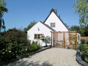 a white house with a gate in a garden at May Cottage in Bacton