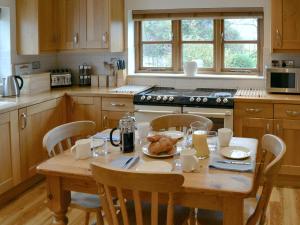 a kitchen with a wooden table with food on it at May Cottage in Bacton +8 photos