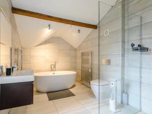a bathroom with a tub and a glass shower at Cragdale Penthouse in Settle