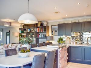 a kitchen with blue cabinets and a table and chairs at The Old Stables in Glasgow