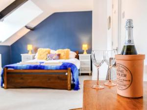 a bottle of wine and two glasses on a table in a bedroom at Ty Afon in Talybont