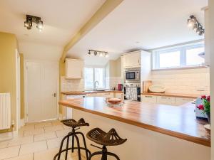 a large kitchen with a counter and stools in it at Ty Afon in Talybont