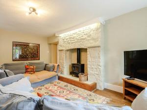 a living room with a couch and a fireplace at Ty Afon in Talybont +19 photos