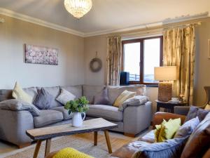 a living room with a couch and a table at Maes Y Bryn Farmhouse in Llanwrda