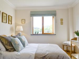 a bedroom with a white bed and a window at Maes Y Bryn Farmhouse in Llanwrda