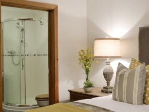 a bedroom with a shower with a bed and a lamp at Maes Y Bryn Farmhouse in Llanwrda +28 photos