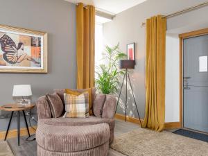 a living room with a chair and a table at Formans Lodge in Musselburgh