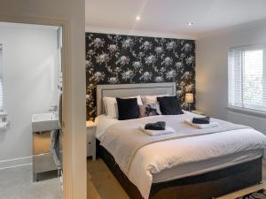 a bedroom with a large bed with a black and white wall at Oswald House in Llansantffraid +16 photos