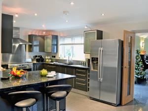 a kitchen with a stainless steel refrigerator and a counter at Oswald House in Llansantffraid