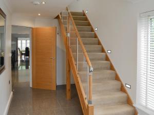 a staircase in a house with a wooden door at Oswald House in Llansantffraid
