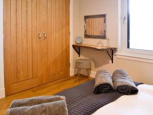 a bedroom with a bed with towels on it at The Byre in Castle Douglas