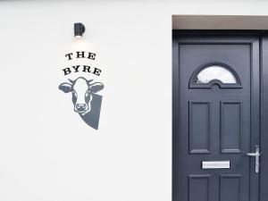 a door to a house with a cow stencil on it at The Byre in Castle Douglas +26 photos