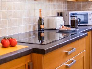 a bottle of wine sitting on top of a kitchen counter at Willow Cottage-Uk2788 in Penmaen-mawr
