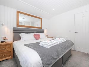 a bedroom with a bed with towels on it at Clyde View in Langbank +7 photos