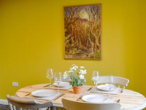 a dining room table with chairs and a painting on the wall at Dutch Barn One - Uk12872 in Brynkir