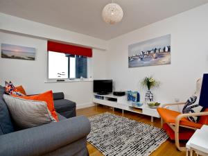a living room with a couch and a tv at 42 Ocean 1 in Crantock