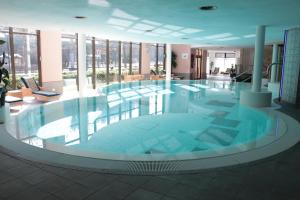 a large swimming pool in a building with windows at Hotel Habichtstein in Alexisbad
