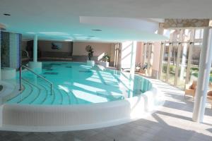 a large swimming pool in a building at Hotel Habichtstein in Alexisbad +60 photos