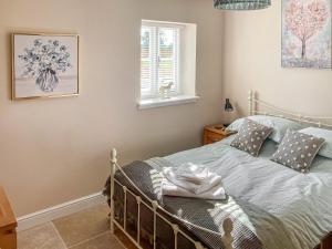 a bedroom with a bed and a window at Barnyard in Chetnole
