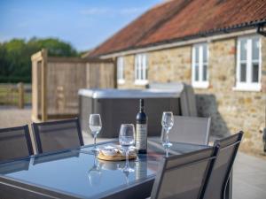 a table with a bottle of wine and two glasses at Barnyard in Chetnole