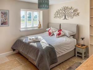a bedroom with a bed with a tree on the wall at Barnyard in Chetnole +22 photos