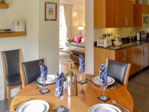a dining room table with chairs and a kitchen at Carnethic House - One Acre View in Fowey