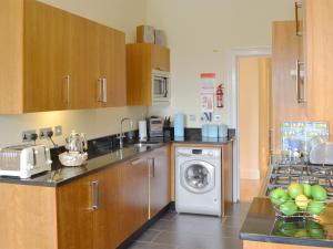 a kitchen with a washing machine and a dishwasher at Carnethic House - One Acre View in Fowey