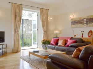 a living room with a couch and a table at Carnethic House - One Acre View in Fowey