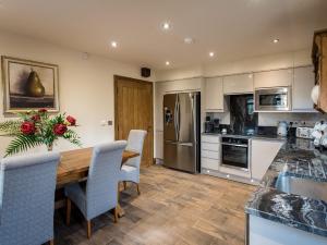 a kitchen with a wooden table and chairs at Cedar Barn - Uk33352 in Buttershaw