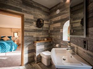 a bathroom with a sink and a toilet and a bed at Cedar Barn - Uk33352 in Buttershaw