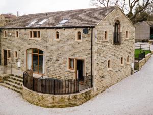 a brick building with a fence around it at Cedar Barn - Uk33352 in Buttershaw +8 photos