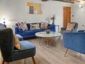 a living room with blue couches and a table and chairs at Smallbrook Cottage - Uk50922 in Salisbury